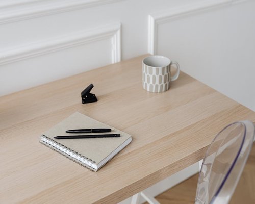 A clean office desk with a coffee mug, water bottle, and a notebook in Mexico City
